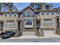 Charming brick townhome featuring a two-car garage, well-maintained landscaping, and inviting front entrances at 1372 Doublegate Dr, Atlanta, GA 30319