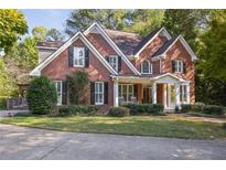 Elegant two-story brick home featuring a welcoming front porch and beautifully landscaped front yard at 415 Westlake Nw Ct, Marietta, GA 30064