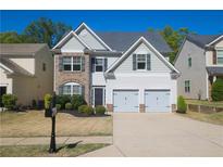 Charming two-story home with a well-maintained lawn, attached two-car garage, and manicured landscaping at 175 Diamond Ridge Ave, Canton, GA 30114