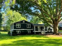 Charming two-story home with a lush green lawn and mature trees providing shade at 213 Mccready Dr, Dallas, GA 30157