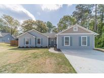 Charming single-story home with light blue siding, shutters, and manicured front lawn at 315 Fieldridge Dr, Lawrenceville, GA 30045