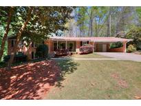 Charming brick home featuring a well-maintained lawn and a convenient covered carport at 1531 Cooper Lake Se Rd, Smyrna, GA 30082