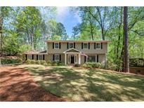 Charming home featuring a large front yard, traditional architecture, and mature trees at 965 River Overlook Ct, Sandy Springs, GA 30328