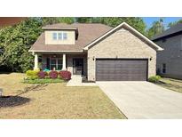 Charming brick home featuring a manicured lawn and a two-car garage at 8664 Spivey Village Trl, Jonesboro, GA 30236