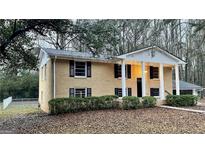 Charming two-story brick home with black shutters and inviting front porch and mature landscaping at 1607 Hillview Ave, Jonesboro, GA 30236