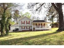 Charming home with a covered porch, red shutters, gray siding, and a detached two-car garage at 24 Lady Savannah Dr, Dallas, GA 30157