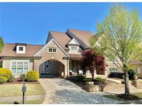 Beautiful brick home featuring a portico, manicured landscaping, and charming curb appeal at 311 Carmichael Cir, Canton, GA 30115