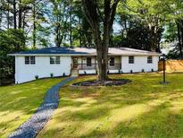 Charming white brick home featuring a welcoming front porch and meticulously landscaped yard at 800 Kiowa Ne Dr, Marietta, GA 30060