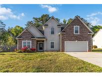 Charming two-story home featuring a stone and siding facade, a well-manicured lawn, and an attached two-car garage at 113 Highgrove Pl, Mcdonough, GA 30253