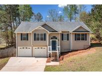 Charming two-story home featuring a two-car garage, a well-manicured front yard, and inviting curb appeal with mature trees at 33 Blue Springs Way, Dallas, GA 30157