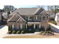 Beautiful two-story brick home featuring a well-manicured lawn and inviting front porch area at 4881 Belle Estates Rd, Suwanee, GA 30024