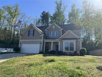 Charming two-story home featuring a two-car garage, neutral siding, and well-manicured lawn at 231 Creek View Pl, Canton, GA 30114
