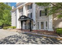 Elegant building entrance with columns, covered awning, and brick walkway at 3648 Peachtree Ne Rd # 2Q, Atlanta, GA 30319