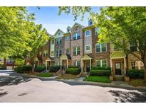 Charming townhomes with varied facades, manicured greenery, and tree-lined street at 1233 Ashford Creek Ne Park, Atlanta, GA 30319