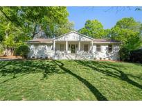 Charming one-story white home with a landscaped yard and beautiful lawn at 1305 Old Woodbine Rd, Atlanta, GA 30319