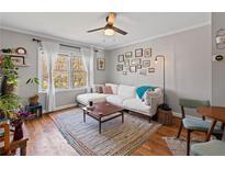 Bright living room features a ceiling fan, hardwood floors, and a comfortable white couch at 542 Goldsboro Ne Rd # C, Atlanta, GA 30307