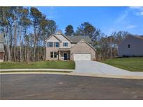 Charming two-story brick home with a well-manicured lawn and attached two-car garage at 128 Felicity Pike, Locust Grove, GA 30248
