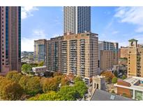 A full exterior view of the building showing its height in the city skyline and surrounding trees at 620 Peachtree Ne St # 1412, Atlanta, GA 30308