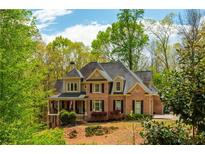 Beautiful brick home with mature trees and manicured landscaping providing excellent curb appeal at 107 Estates At The Lake Dr, Canton, GA 30114