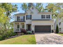 Charming two-story home featuring black shutters, a two-car garage, and a beautifully landscaped front yard at 4965 Skyland Pkwy, Cumming, GA 30028