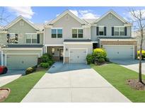 Inviting townhouse exterior with driveway, attached garage, and well-maintained lawn, complete with colorful landscaping at 1439 Brookmere Way, Cumming, GA 30040