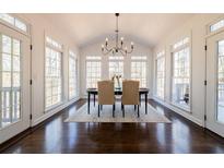 Bright dining room features large windows, hardwood floors, a modern chandelier and vaulted ceiling at 1250 Northcliff Trce, Roswell, GA 30076
