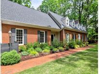 Charming brick home featuring a well-manicured lawn, beautiful landscaping and a red brick walkway at 1250 Northcliff Trce, Roswell, GA 30076