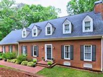 Beautiful brick home with dormer windows, black shutters and a landscaped front yard with a brick walkway at 1250 Northcliff Trce, Roswell, GA 30076