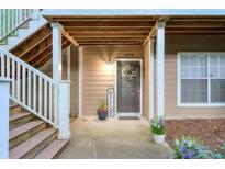Inviting condo entrance featuring a welcome sign, potted flowers, and covered porch and staircase at 2120 River Heights Se Walk, Marietta, GA 30067