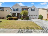 Charming two-story home featuring a well-manicured lawn, landscaped beds, and a two-car garage at 2238 Well Springs Dr, Buford, GA 30519