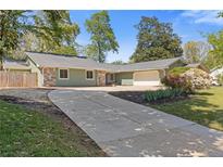 Charming single-story home with a stone facade, light-green wood siding, and a spacious concrete driveway at 350 Somerset Se Ln, Marietta, GA 30067