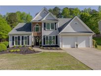 Charming two-story home features a well-manicured lawn, two-car garage, and inviting front entrance at 513 Huntgate Rd, Woodstock, GA 30189