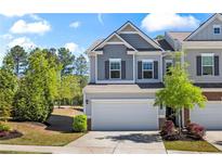 Two-story home with gray siding, two-car garage, and landscaped front yard at 136 Grant Dr, Canton, GA 30114