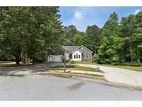 Charming one-story home with stone accents, well-maintained lawn, and a spacious driveway at 1945 Grayson Oaks Ct, Lawrenceville, GA 30045