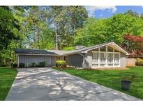 Charming single-story home featuring a well-manicured lawn, mature trees, and a long driveway at , Stone Mountain, GA 30088
