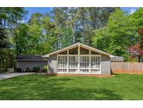 Charming home featuring a well-manicured lawn and a unique window-filled sunroom at , Stone Mountain, GA 30088