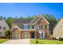Charming two-story home with brick and siding exterior, well-manicured lawn, and a two-car garage at 5424 Landsdowne Ct, Cumming, GA 30041