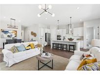 Bright, open-concept living space flows into a modern kitchen with a large island and stainless steel appliances at 3698 Annsbury Ct, Lilburn, GA 30047