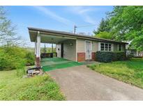 Ranch style home with covered porch, driveway, and mature trees at 5335 Old Floyd Sw Rd, Mableton, GA 30126