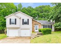 Charming home featuring a two-car garage, stone accents, neutral siding and nicely landscaped yard at 402 Leslie Ct, Mcdonough, GA 30253