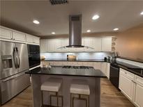 Modern kitchen with stainless steel appliances, white cabinets, and a center island with bar stool seating at 4130 Overland Dr, Roswell, GA 30075