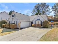 Charming one-story home featuring manicured landscaping and a two-car garage on a sunny day at 1325 Richland Creek Ct, Sugar Hill, GA 30518