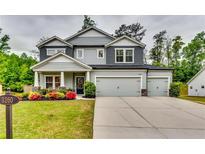 Charming two-story home with three-car garage and beautifully landscaped front yard at 3260 Summerpoint Xing, Cumming, GA 30028