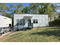 Modern home with a stylish exterior, featuring a charming front porch and landscaped yard at 952 Bruce Se Cir, Atlanta, GA 30316