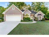 Charming home featuring well-manicured lawn, stone accents, and a two-car garage at 705 Branch Tree Way, Lawrenceville, GA 30043