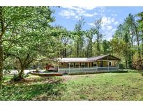 Charming single-story home with a large yard, mature trees, and inviting front porch at 4653 Anns Se Trce, Acworth, GA 30102