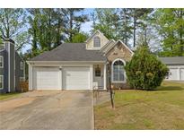 Charming home with a two-car garage, stone accents, and a well-manicured front yard at 536 Crestridge Ct, Stone Mountain, GA 30083