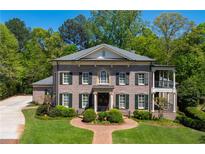 Stunning brick home featuring lush landscaping, a balanced facade, and an inviting entrance at 385 Laurel Chase Ct, Atlanta, GA 30327