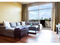 Bright living room with a large window view of the city skyline and comfortable seating at 711 Cosmopolitan Ne Dr # 715, Atlanta, GA 30324