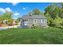 Charming single-story home with a well-manicured lawn and gray siding and trim at 5024 Park Ave, Forest Park, GA 30297